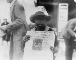 A little boy selling newspapers, 1921.