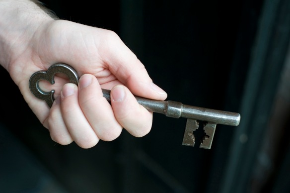 Hand holding a metallic vintage key